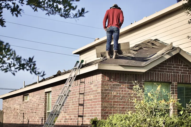 Professional roofer working on a residential roof in Linton